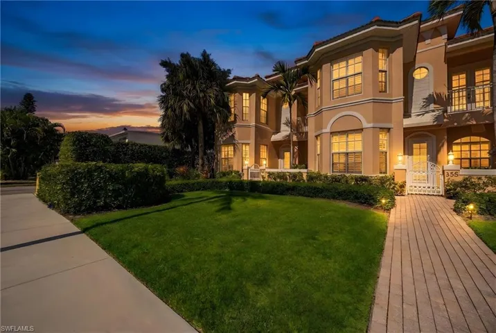 Mediterranean / spanish-style house with a balcony, stucco siding, and a front lawn