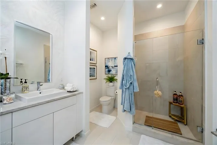 Full bath featuring a stall shower, vanity, light tile patterned floors, and recessed lighting