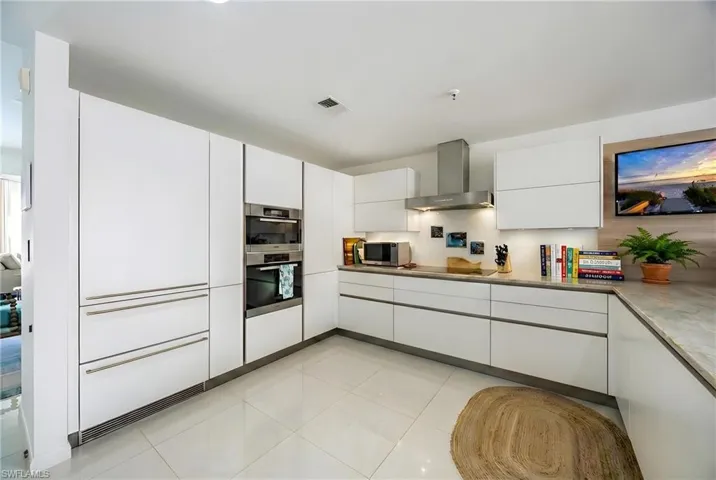 Kitchen featuring white cabinetry, modern cabinets, stainless steel appliances, and light tile patterned floors