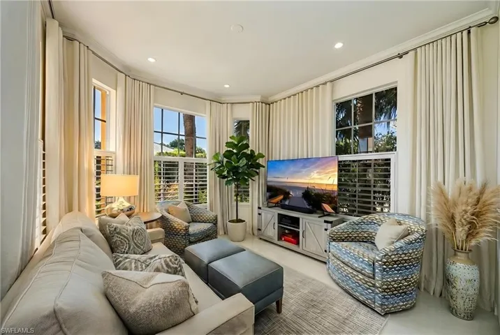 Living area with crown molding and recessed lighting