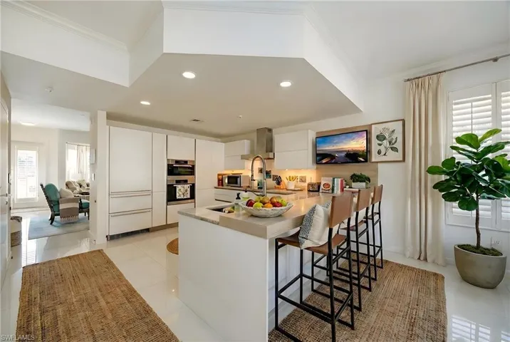 Kitchen featuring healthy amount of natural light, a kitchen breakfast bar, modern cabinets, a peninsula, and recessed lighting