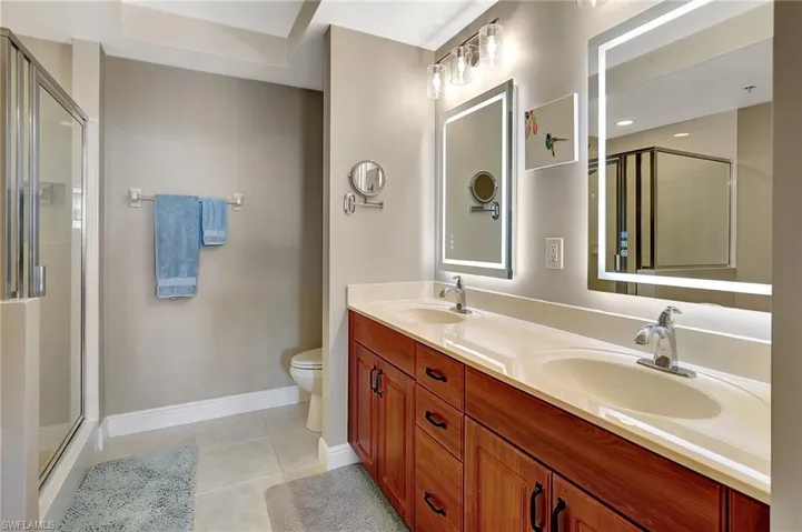 Bathroom featuring tile patterned floors, toilet, an enclosed shower, and vanity
