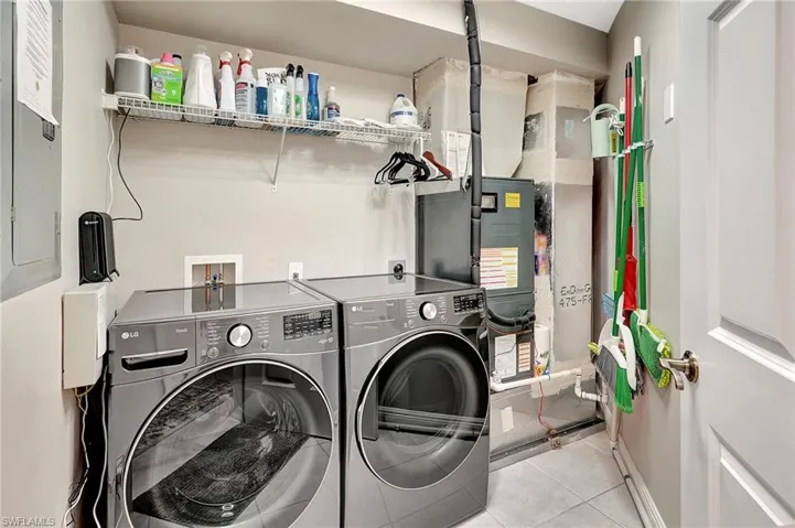 Laundry area featuring light tile patterned floors and washing machine and dryer