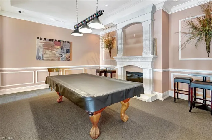 Playroom with billiards, ornamental molding, carpet flooring, and a high end fireplace