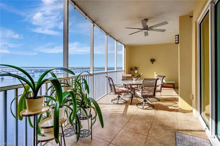 Sunroom featuring a water view and ceiling fan