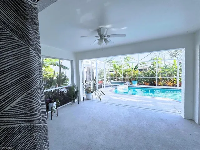 View of pool from kitchen with full lanai, resurfaced patio (2024), a pool with connected hot tub