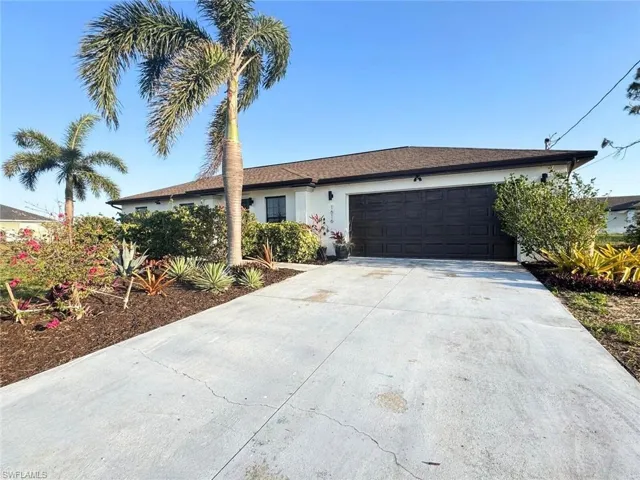 Ranch-style home with an attached garage, driveway, and stucco