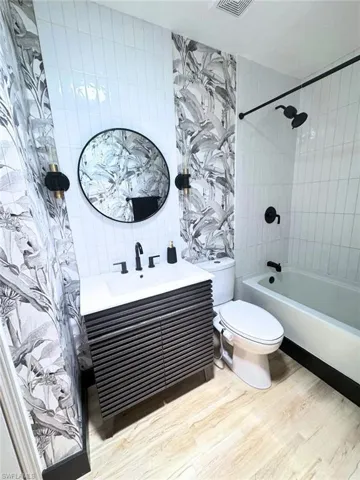 Bathroom featuring vanity, shower / bath combination, toilet (2024)
