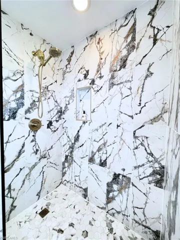 Walk-in shower features new plumbing and frameless glass wall