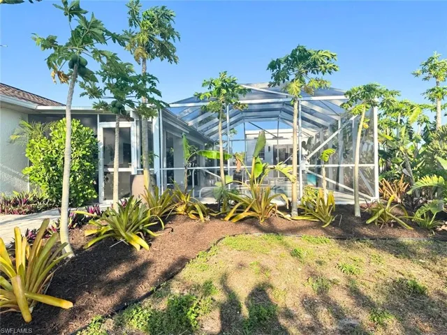 View of yard featuring tropical landscaping and fruit plants