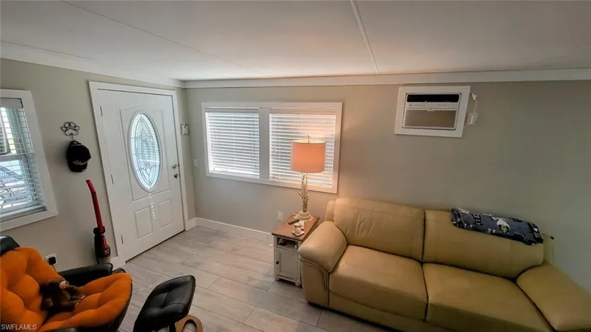Entrance foyer with wood tiled floors and a wall mounted air conditioner