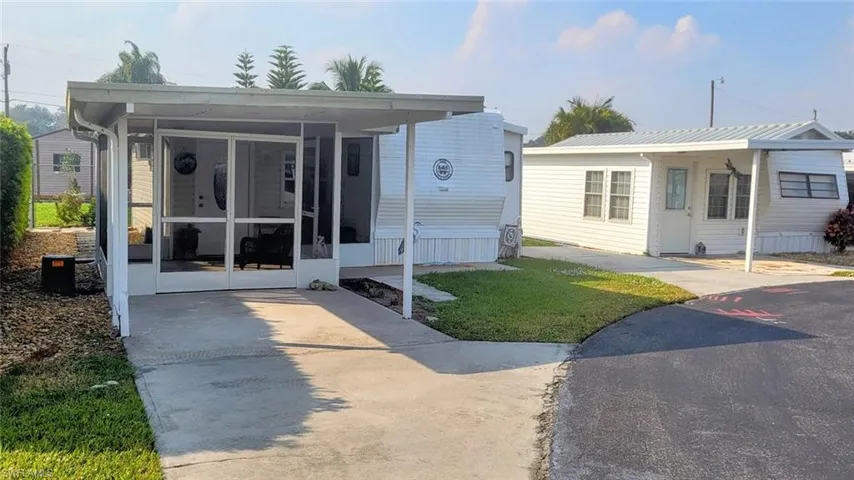 View of front facade with a sunroom and a front yard