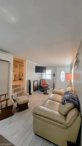 Living area featuring wood finished floors and a wall unit AC