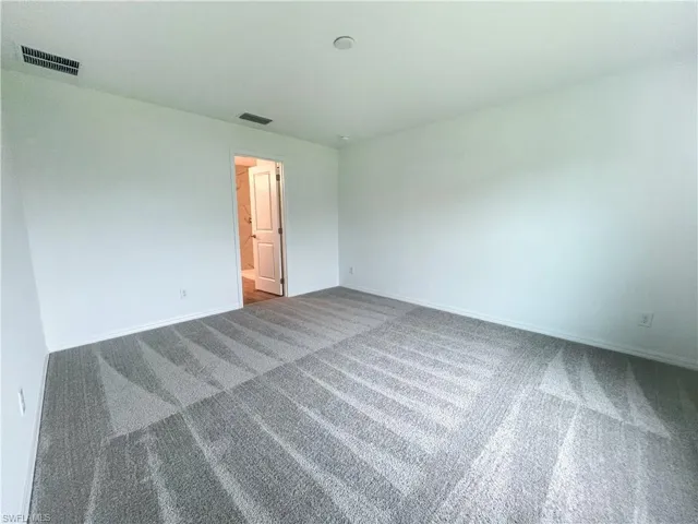 Carpeted spare room with baseboards