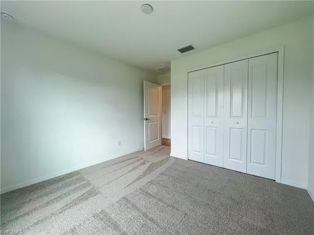 Unfurnished bedroom featuring carpet flooring and a closet
