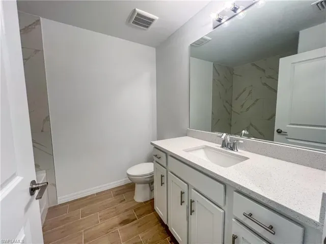 Bathroom featuring vanity, wood tiled floors, and shower / bath combination