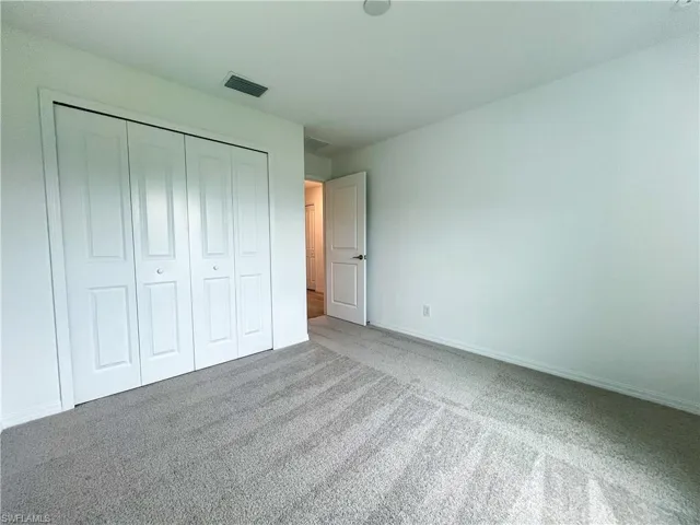 Unfurnished bedroom with carpet and a closet