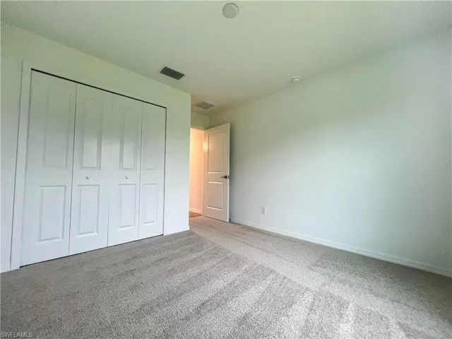 Unfurnished bedroom with carpet and a closet