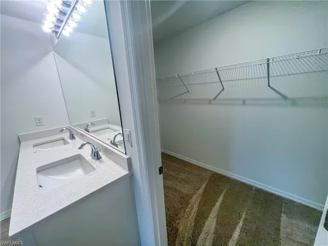 Bathroom with a walk in closet and double vanity