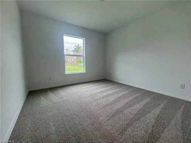 Empty room with carpet and baseboards