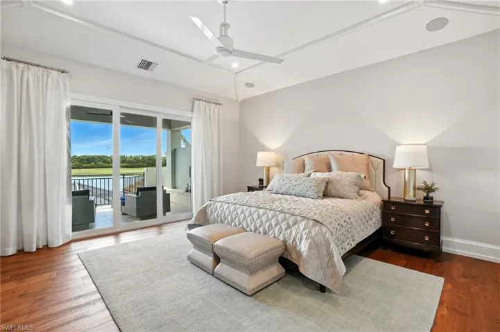 Bedroom featuring wood finished floors, recessed lighting, access to exterior, a water view, and a ceiling fan
