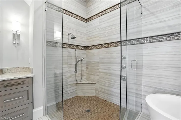 Bathroom with a stall shower, a freestanding tub, and vanity