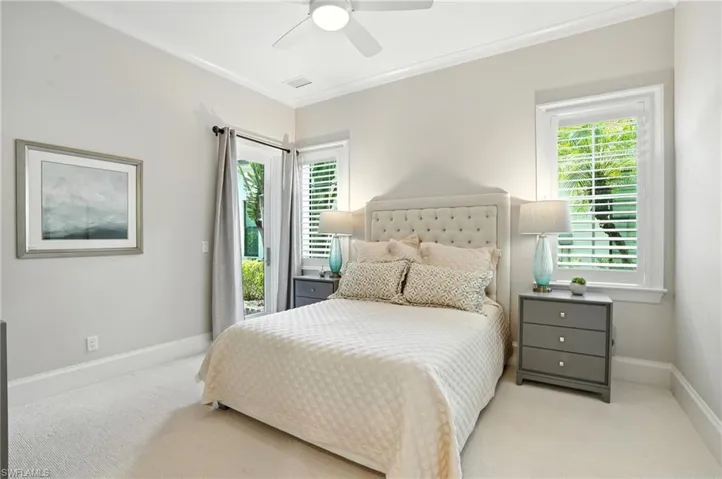 Carpeted bedroom featuring crown molding, access to exterior, and a ceiling fan