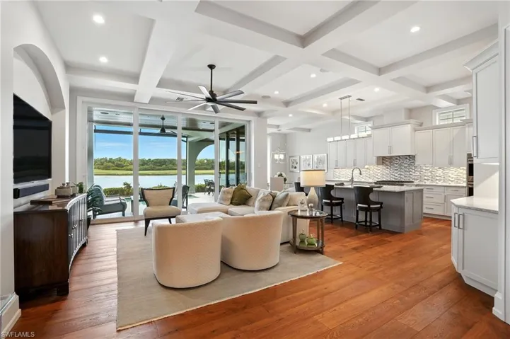 Living area with coffered ceiling, beam ceiling, healthy amount of natural light, light wood-type flooring, and recessed lighting