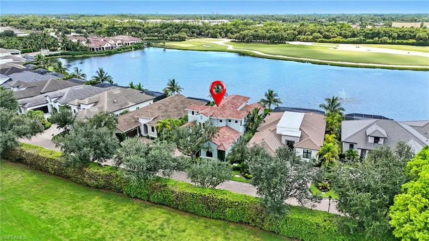 Aerial view of residential area with a nearby body of water and a golf course