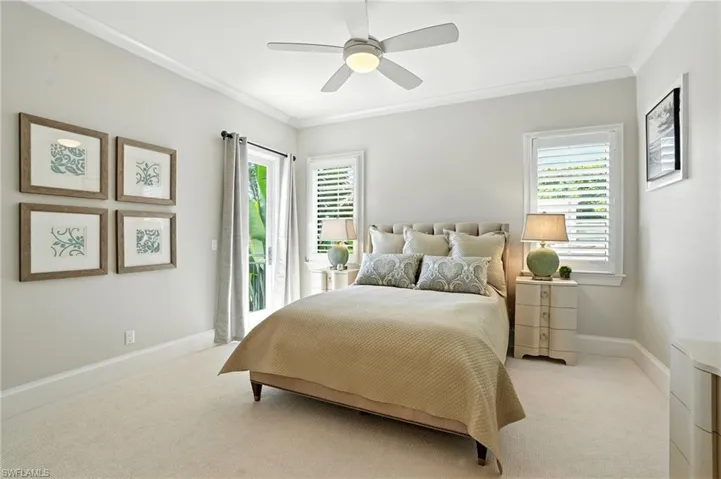 Carpeted bedroom with access to exterior, ornamental molding, and ceiling fan