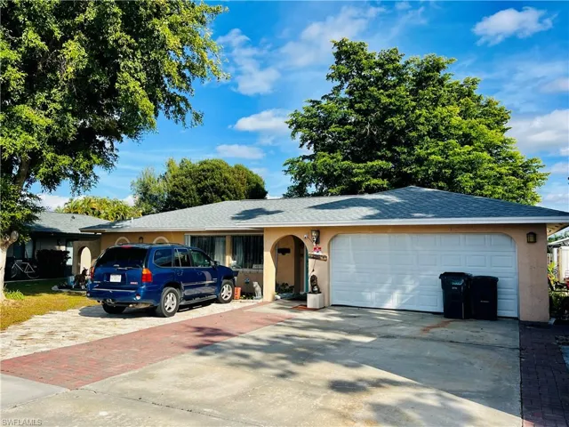 Ranch-style house featuring concrete driveway, a shingled roof, and a garage