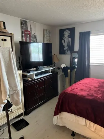 Bedroom with a textured ceiling and light wood finished floors
