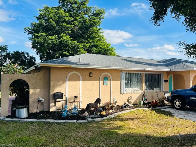 View of home's exterior with a lawn, stucco siding, and a shingled roof