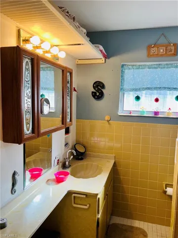 Bathroom featuring vanity, tile walls, and wainscoting