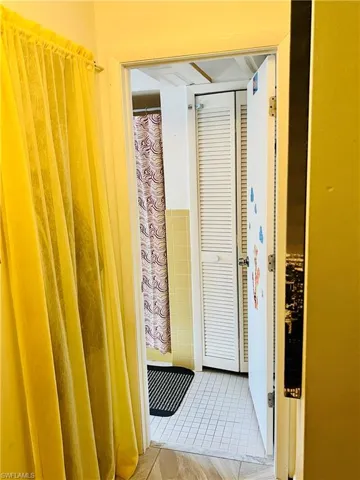 Full bathroom featuring tile walls, light tile patterned floors, and shower / tub combo