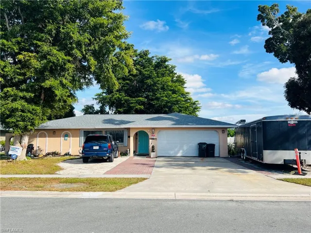Single story home featuring concrete driveway, a garage, stucco siding, and a shingled roof