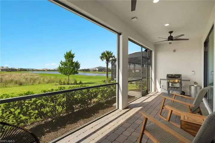 Sunroom / solarium with ceiling fan and a water view