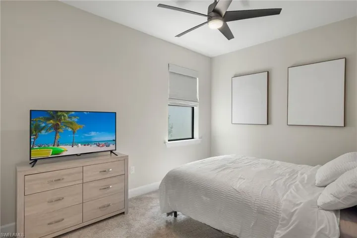 Carpeted bedroom featuring ceiling fan
