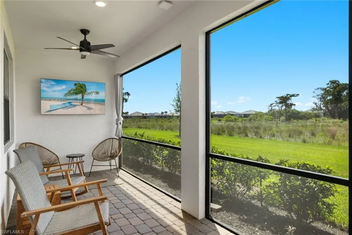 Sunroom / solarium with ceiling fan and a rural view