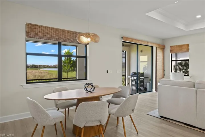 Dining space featuring crown molding, light hardwood / wood-style floors, and a raised ceiling