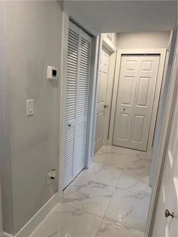 Bathroom with a closet and light marble finish flooring