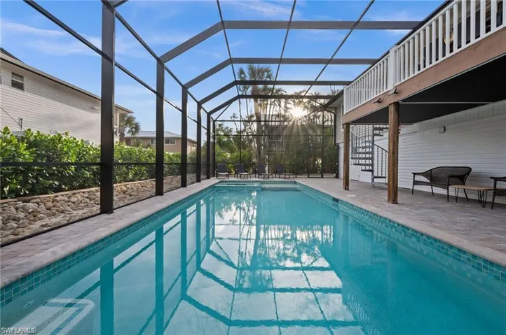 View of pool featuring glass enclosure and a patio area