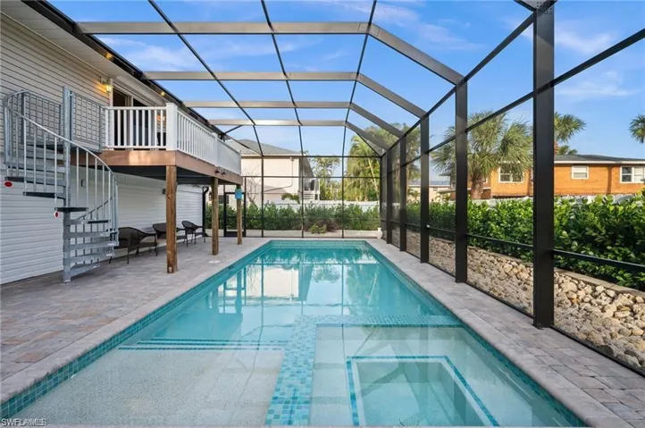 View of pool featuring an in ground hot tub, a patio, and a lanai