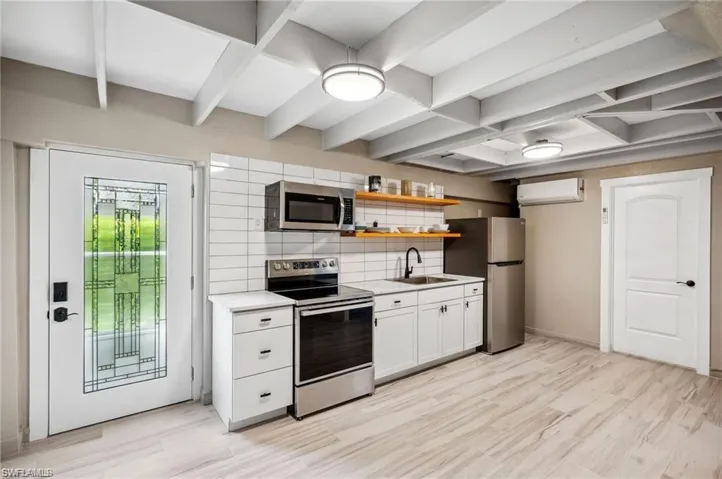 Kitchen featuring white cabinetry, sink, light hardwood / wood-style floors, and appliances with stainless steel finishes