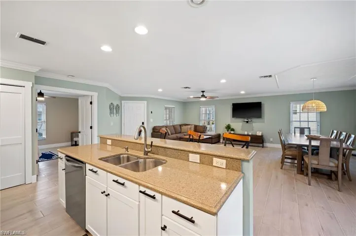 Kitchen with ceiling fan, sink, light hardwood / wood-style flooring, an island with sink, and white cabinets