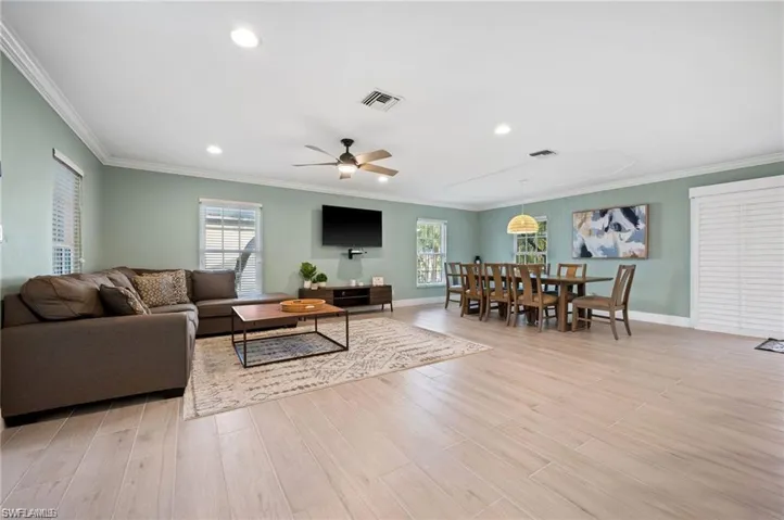 Living room featuring ceiling fan, light hardwood / wood-style floors, and ornamental molding