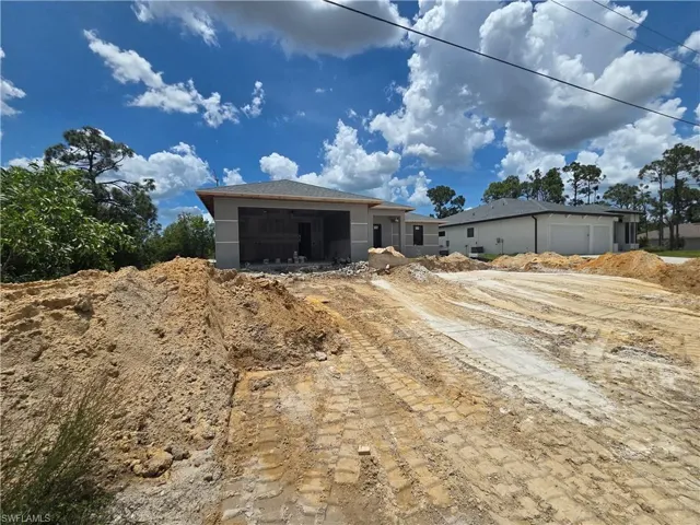 New construction property featuring a stucco exterior, a dark gray shingle roof, and a visible garage door opening