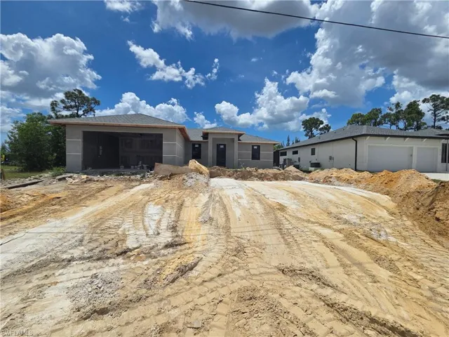 New construction residence featuring a gray shingle roof, unfinished exterior walls, and an integrated garage space