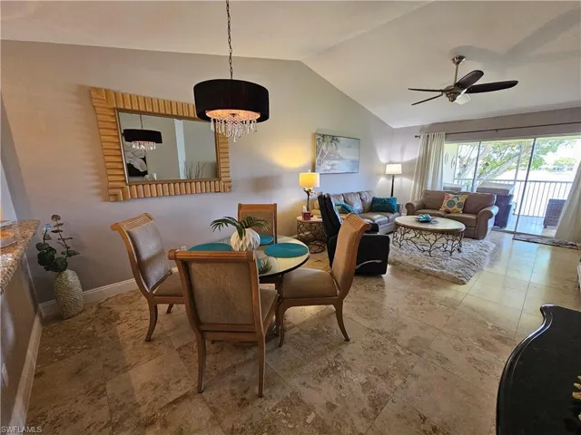 Dining room featuring vaulted ceiling, tile flooring, and ceiling fan