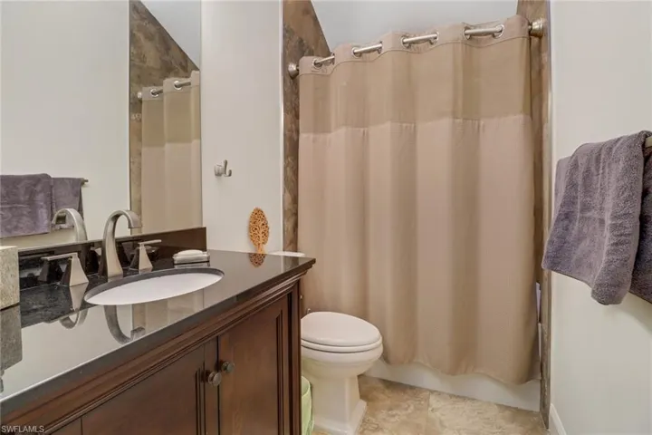 Bathroom with vanity and shower / tub combo with curtain